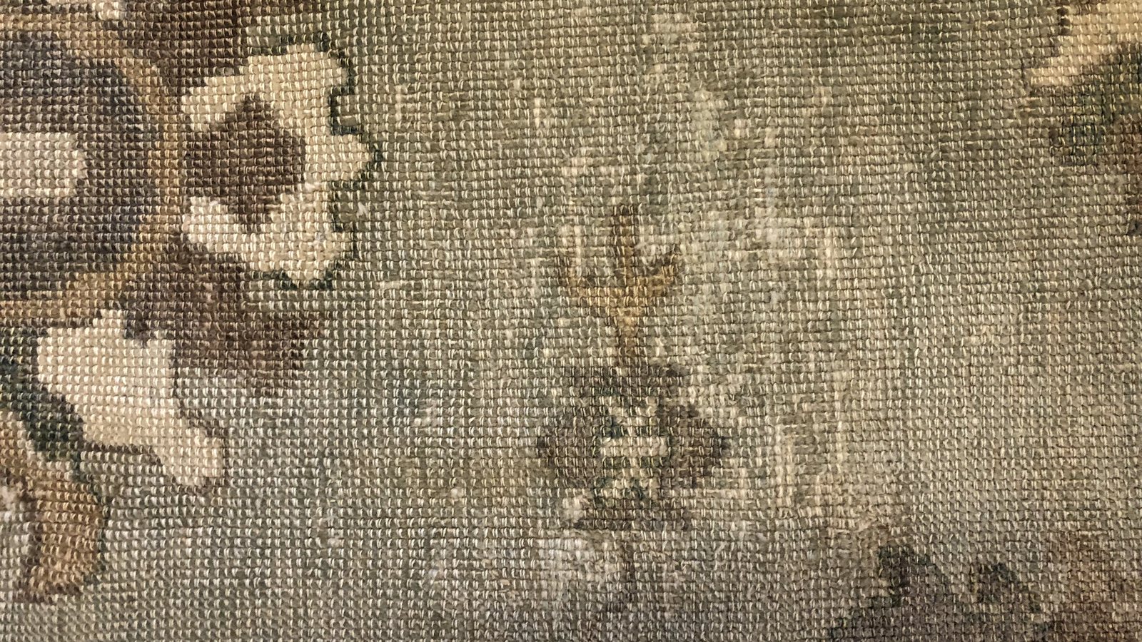 The reverse of a wool rug, where filtration lines and damp in the cotton foundation show before the pile gives them away